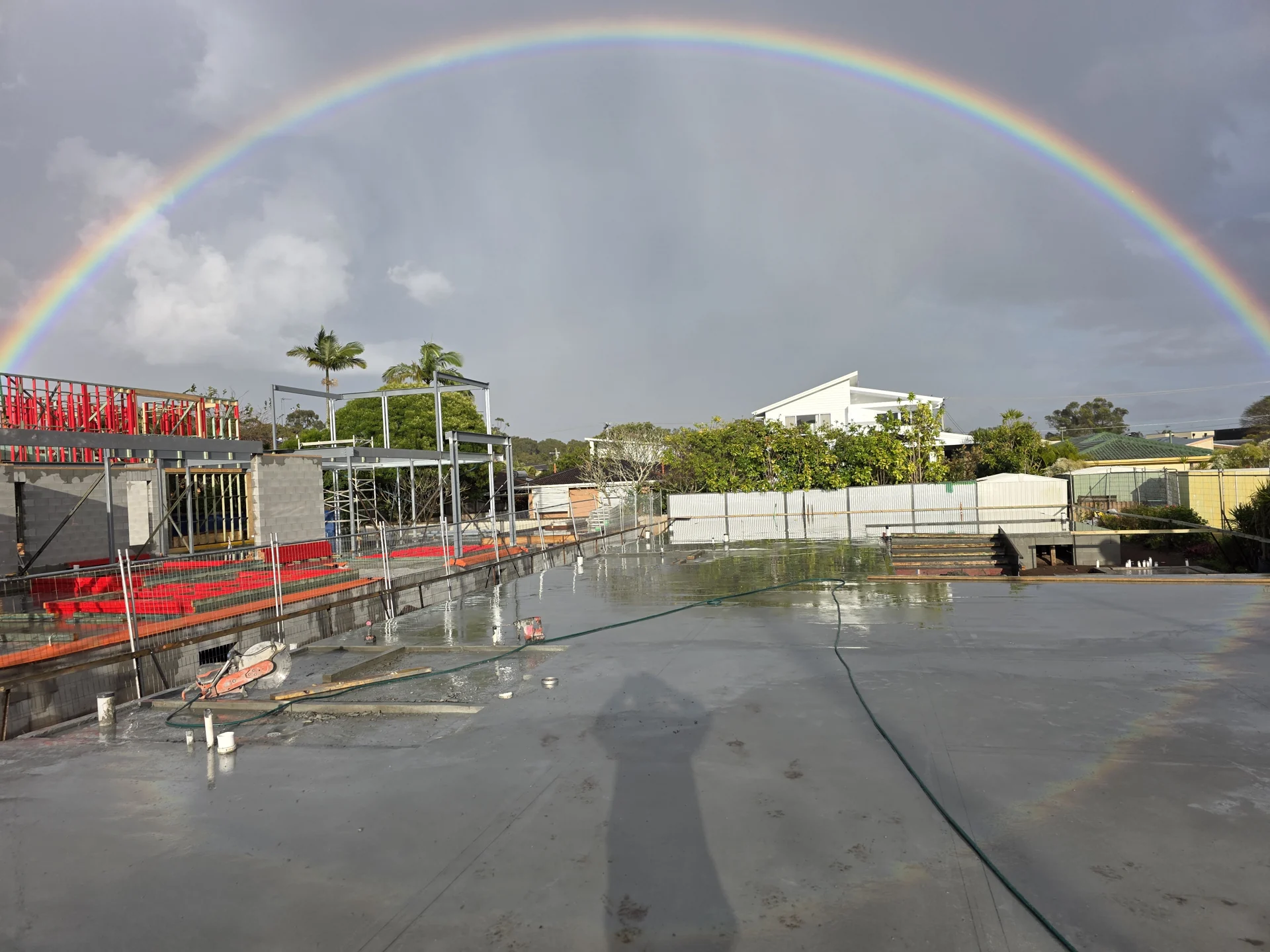 WCD concrete slab beneath a rainbow on a Gold Coast construction site
